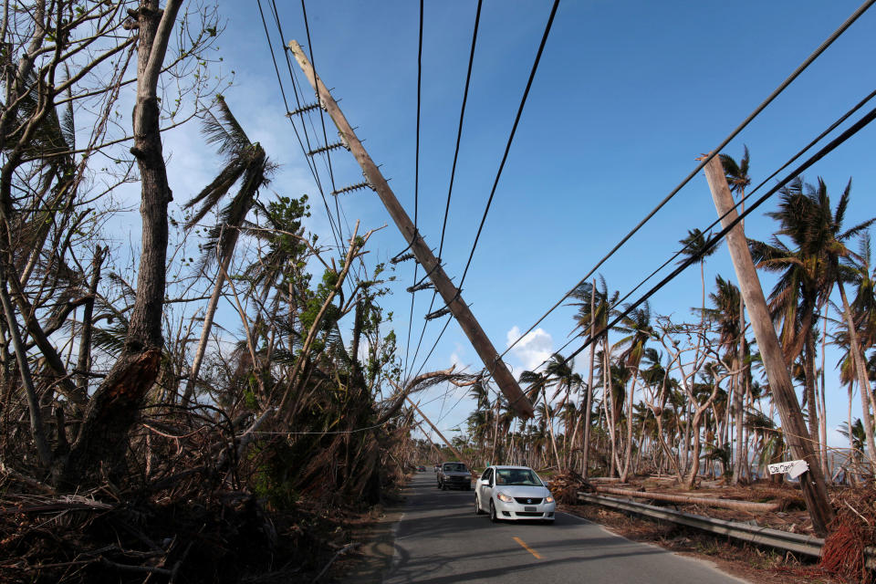 FILE PHOTO: Cars drive under a partially collapsed utility pole, after the island was hit by Hurricane Maria in September, in Naguabo, Puerto Rico October 20, 2017. REUTERS/Alvin Baez/File Photo