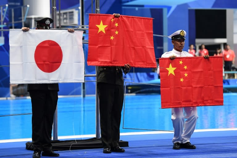 Officials had to hold up the Chinese and Japanese flags after they fell down during a victory ceremony at the Asian Games swimming pool