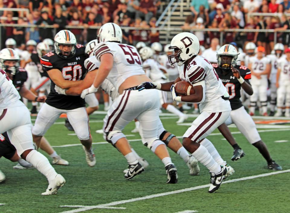 Dowling Catholic junior running back Ra'Shawd Davis (24) follows Dowling Catholic senior offensive lineman and Kansas State commit Kyle Rakers (55) in a game against Valley earlier this season.
