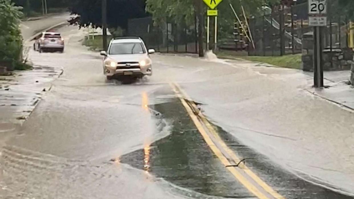 PHOTO: Cars drive on a flooded road in Highland Falls, Orange County, July 9, 2023 in this screengrab obtained from social media video. (@aichelbee via Reuters)