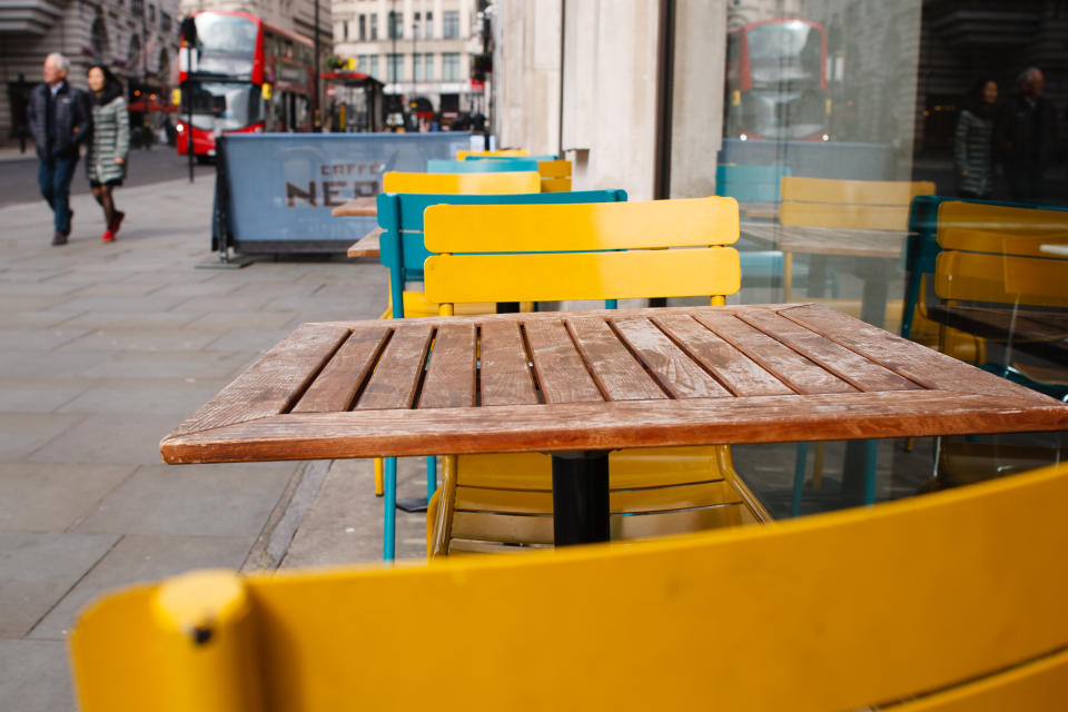 Tables and chairs stand vacant outside a branch of Pizza Express on Haymarket in London.