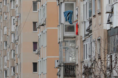 A woman hauls dust from a bed cover from the window of a communist era block of flats in Bucharest, Romania, November 23, 2016. Inquam Photos/Octav Ganea/via REUTERS