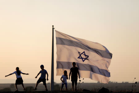 Israeli kids play next to an Israeli flag next to the Israeli Syrian border at the Israeli-occupied Golan Heights, Israel July 23, 2018. REUTERS/Ronen Zvulun