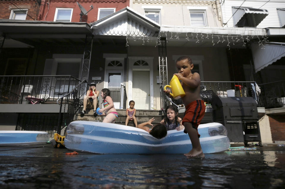 Jayden Jones, from right, 2, Veronica Caines, 6, Aliyah Nguyen, 5, Kianna Roman, 4, and Juliann Esola, 5, cool off in a wade pool under the watch of Amber Escola, Monday, July 16, 2012, in Philadelphia. Temperatures in Philadelphia reached the low 90s on Monday. (AP Photo/Matt Slocum)