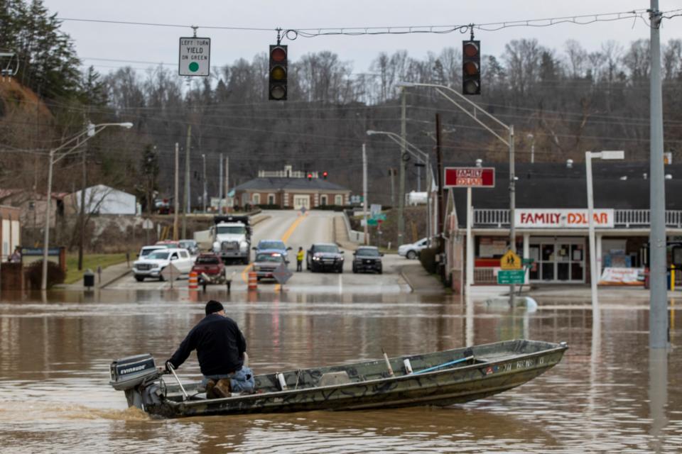 Justin Wade drives a boat down Main Street after high water and flooding filled downtown Beattyville after heavy rains led Kentucky River waters overflowing Sunday evening. March 1, 2021