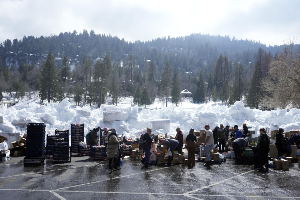 Food is distributed out of a parking lot after a series of storms, Wednesday, March 8, 2023, in Crestline, Calif. (AP Photo/Marcio Jose Sanchez)