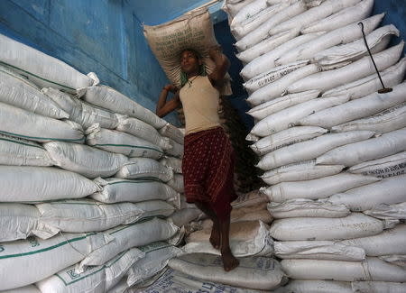 A labourer carries a sack filled with sugar in a store at a wholesale market in Kolkata, India, February 15, 2016. REUTERS/Rupak De Chowdhuri/File Photo