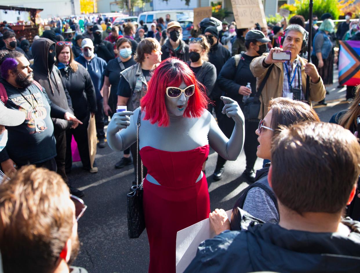 Drag performer Emma Lavin, center, attempts to find middle ground with protesters outside Old Nick's Pub in Eugene Sunday, Oct. 23, 2022. The crowd of protesters showed up to protest the performance of an 11-year-old drag queen at the pub's drag queen story time.
