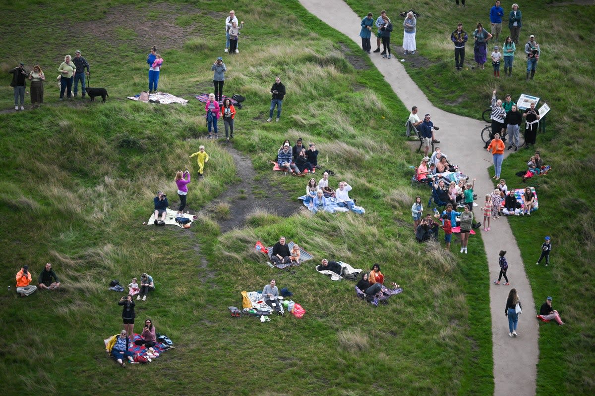 People watch as balloons fly over Bristol during a mass ascent on 11 August 2023 in Bristol, England (Getty Images)