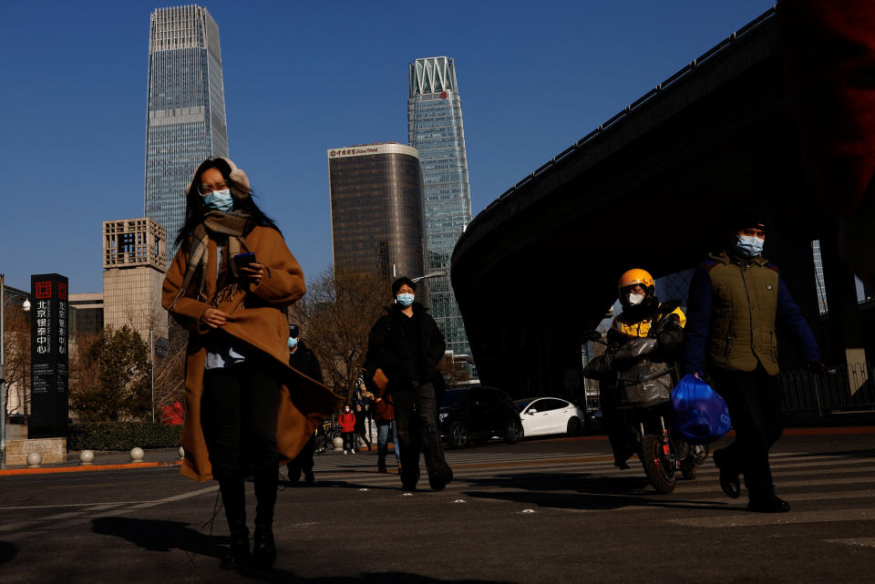 People walk on a street in the Beijing's Central Business District (CBD), during the morning rush hour following the Chinese Lunar New Year holiday, in Beijing, China, January 30, 2023. REUTERS/Tingshu Wang