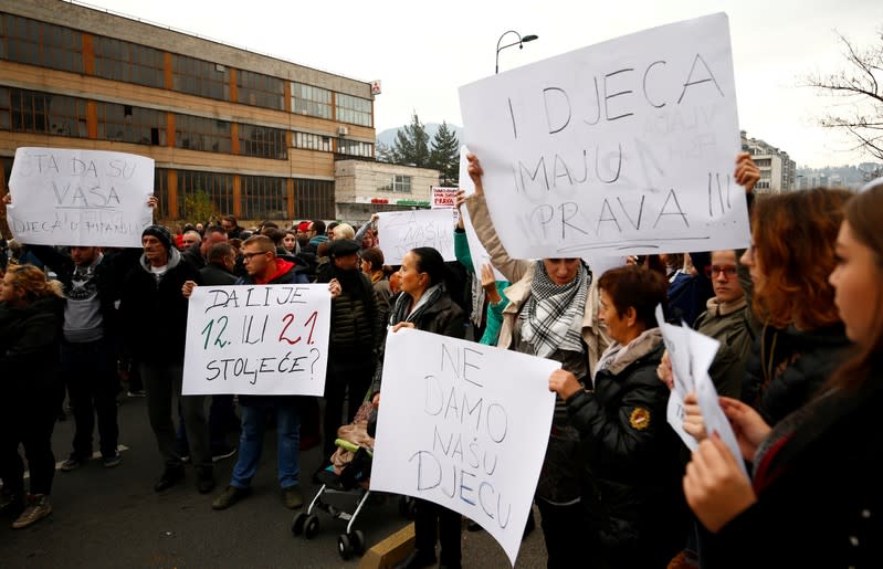 Protesters hold placards during protest against abuse in an institution for children with special needs after photographs emerged of children tied to beds and radiators in Sarajevo