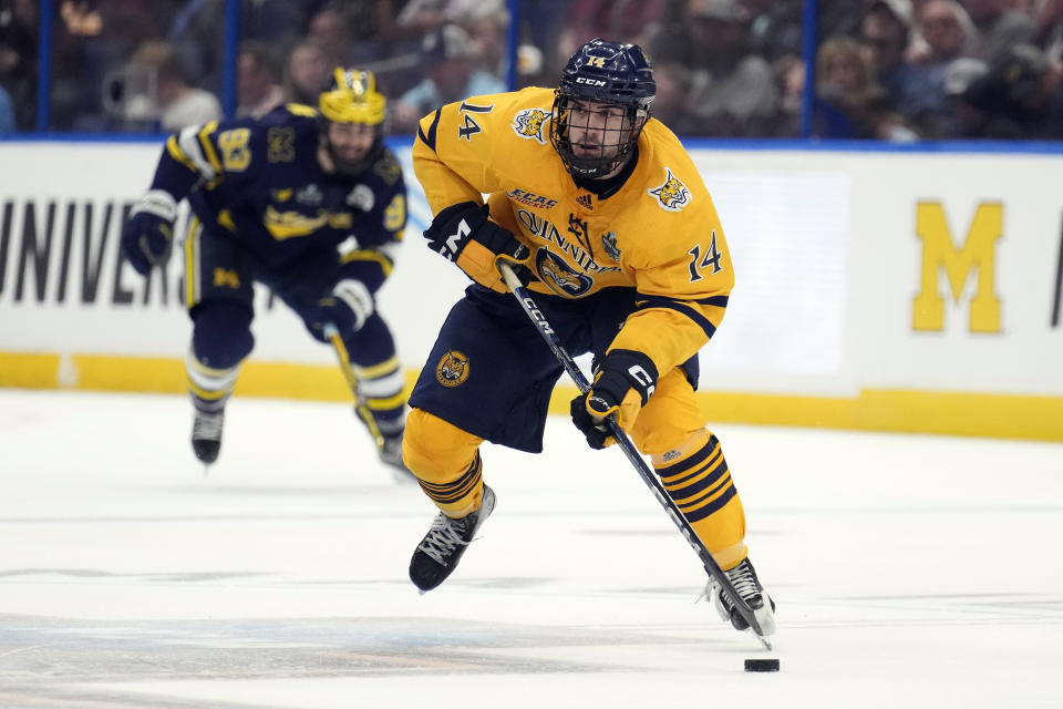 Quinnipiac forward Victor Czerneckianair (14) skates up the ice ahead of Michigan forward Eric Ciccolini (93) during the second period of an NCAA semifinal game in the Frozen Four college hockey tournament Thursday, April 6, 2023, in Tampa, Fla. (AP Photo/Chris O'Meara)