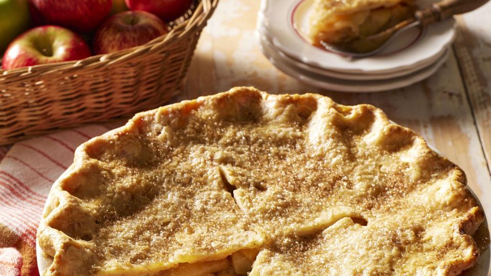 double crust brown butter apple pie in a red pie dish with a slice removed to show the inside