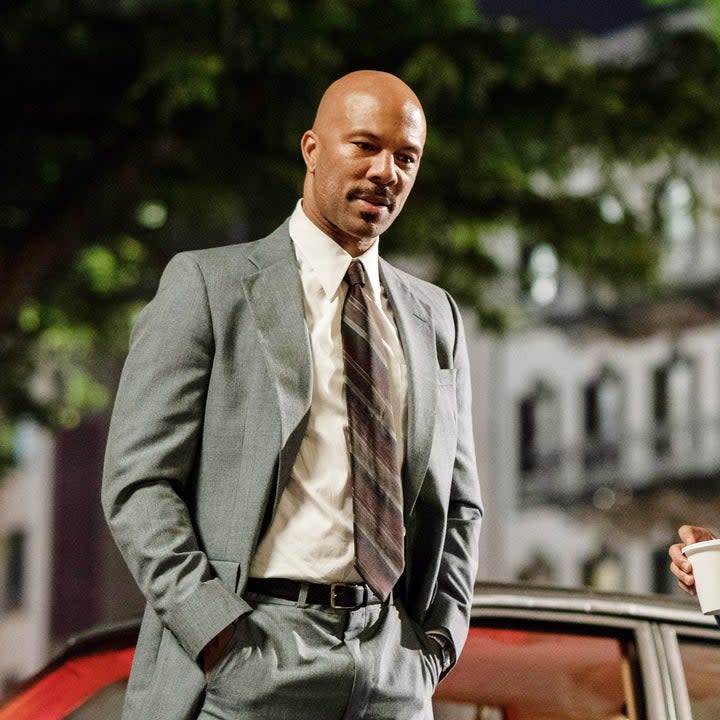 Common in a suit with his hands in his pocket during a scene from The Kitchen