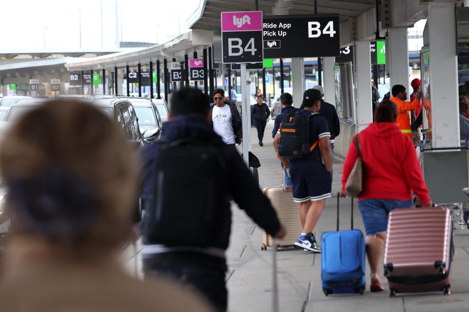 People wait for cars in the Lyft pickup area at JFK Airport on April 28, 2023 in New York City.