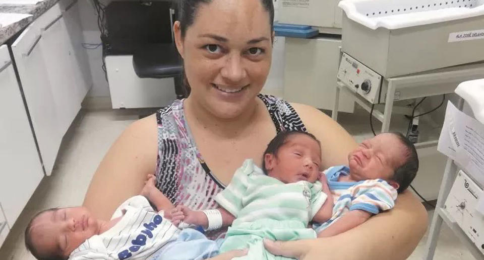 Ana Paula Faria holding her triplet sons in hospital.