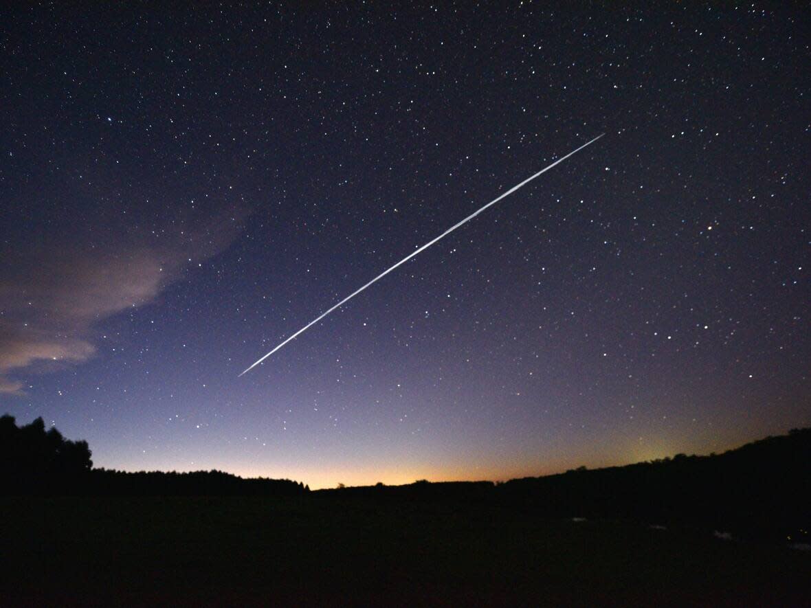 The long-exposure image of a trail of a SpaceX's Starlink satellites passing over Uruguay on Feb. 7, 2021. This week users of the Starlink’s 'RV' internet service in Iqaluit reported that their dishes were picking up a signal. (Mariana Suarez/AFP via Getty Images - image credit)