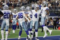 Dallas Cowboys' Tony Pollard (20), Dalton Schultz (86), Dak Prescott (4) and Cedrick Wilson (1) celebrate a touchdown catch made by Wilson in the second half of an NFL football game against the Carolina Panthers in Arlington, Texas, Sunday, Oct. 3, 2021. (AP Photo/Michael Ainsworth)