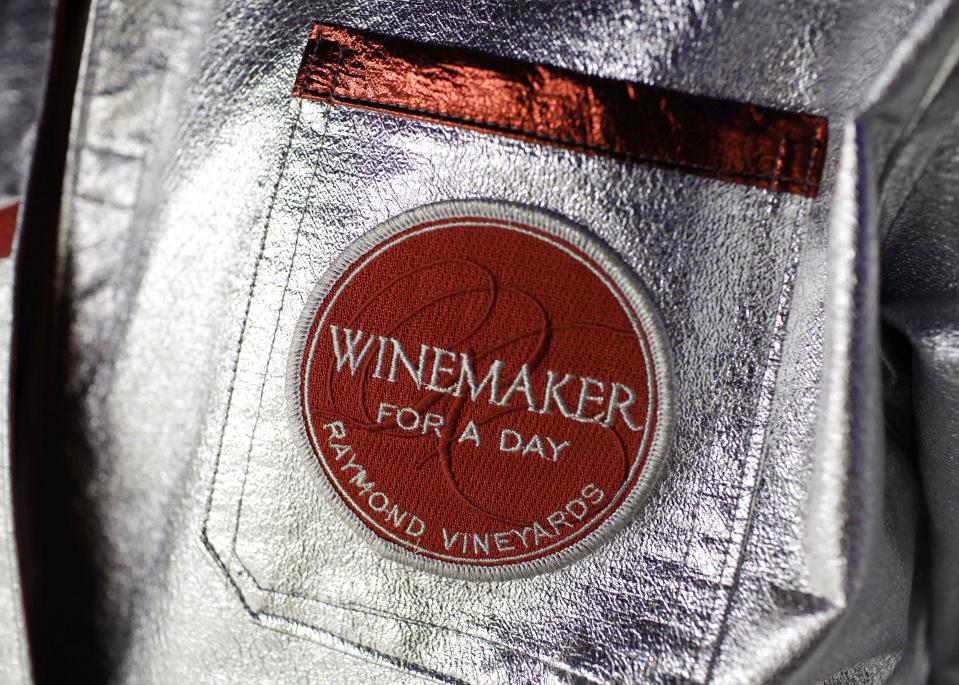 In this photo taken Wednesday, March, 21, 2012, shown is the patch on the lab coat of a participant taking part in the winemaker-for-a-day program at Raymond Vineyards in St. Helena, Calif. Visitors who sign up for the program don silver and red lab coats, with matching hats, naturally, and mix their own wine blends in a room decorated with a disco ball and black light. (AP Photo/Eric Risberg)