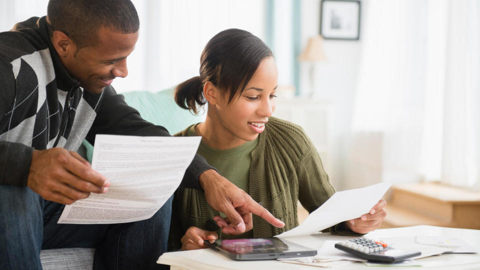 Couple paying bills in living room.