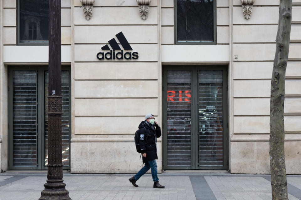 PARIS, FRANCE - MARCH 16: A passerby wears a protective face mask, in front of a closed Adidas store, at Avenue des Champs Elysees, in the 8th quarter of Paris, as the city imposes emergency measures to combat the Coronavirus COVID-19 outbreak, on March 16, 2020 in Paris, France. French Prime Minister Edouard Philippe announced last Saturday that France must shut shops, restaurants and entertainment facilities to slow down the spread of the coronavirus. Due to a sharp increase in the number of cases of the COVID-19 virus declared in Paris and throughout France, several sporting, cultural and festive events have been postponed or cancelled. The epidemic has exceeded 6,500 dead for more than 169,000 infections across the world. During a televised speech dedicated to the coronavirus crisis on March 16, French President, Emmanuel Macron announced that France starts a nationwide lockdown on March 17.  (Photo by Edward Berthelot/Getty Images)