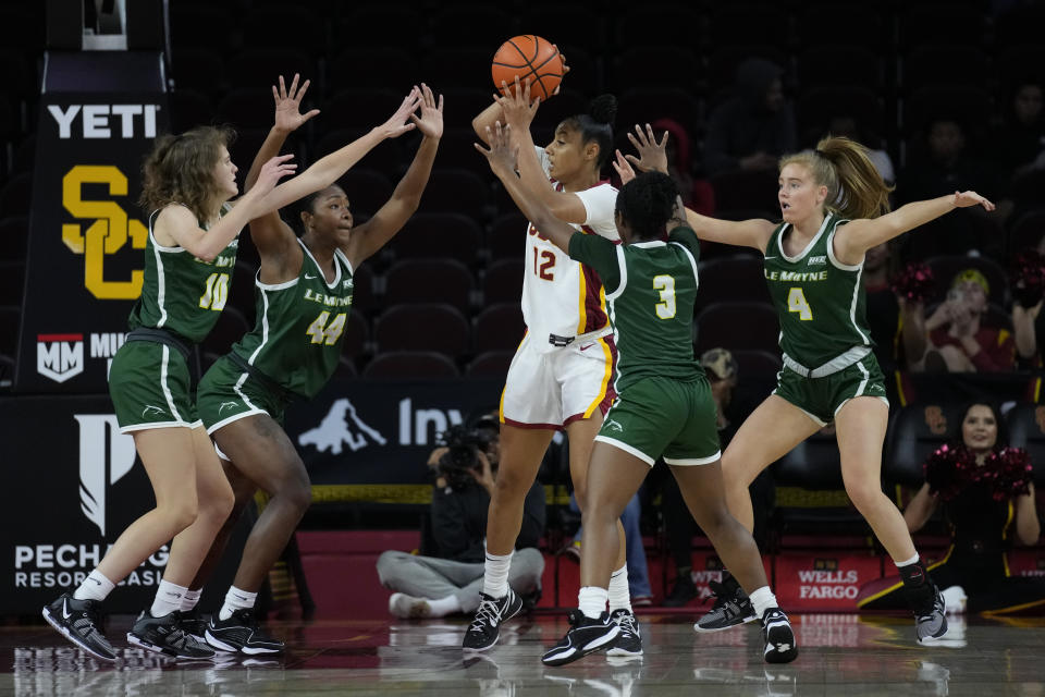 Southern California guard JuJu Watkins (12) is defended by Le Moyne guard Sydney Lusher (10), forward Brianna Williams (44), guard Aaliyah Gayles (3) and guard Kayla Williams (4) during the first half of an NCAA college basketball game in Los Angeles, Monday, Nov. 13, 2023. (AP Photo/Ashley Landis)