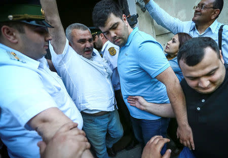 Azerbaijani Journalist Afgan Mukhtarli greets supporters as he is taken to the court in Baku, Azerbaijan May 31, 2017. REUTERS/Aziz Karimov