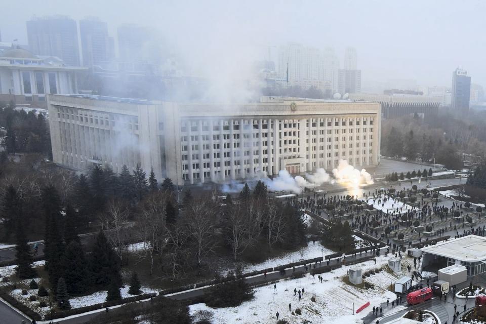 FILE - Smoke rises from the city hall building during a protest in Almaty, Kazakhstan, Wednesday, Jan. 5, 2022. The gatherings were initially peaceful, but over the course of a week, groups of armed men appeared in Almaty, some seen riding in cars without license plates or with their faces covered. Participants of peaceful marches told the AP at the time that these men had urged them to storm government buildings, promising to give them guns. (AP Photo/Yan Blagov, File)