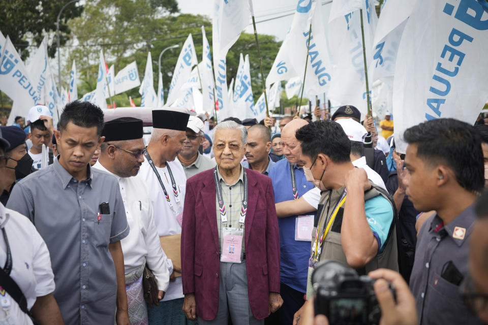 FILE - Malaysia's former Prime Minister Mahathir Mohamad, center, chairman of Gerakan Tanah Air (Homeland Movement) party, walks with his supporters toward the nomination center in Langkawi Island, Malaysia on Nov. 5, 2022. At 97, Mahathir is back again in the election race as the head of a new ethnic Malay alliance that he calls a "movement of the people." He hopes his bloc could gain enough seats in Nov. 19 polls to be a powerbroker. (AP Photo/Vincent Thian, File)