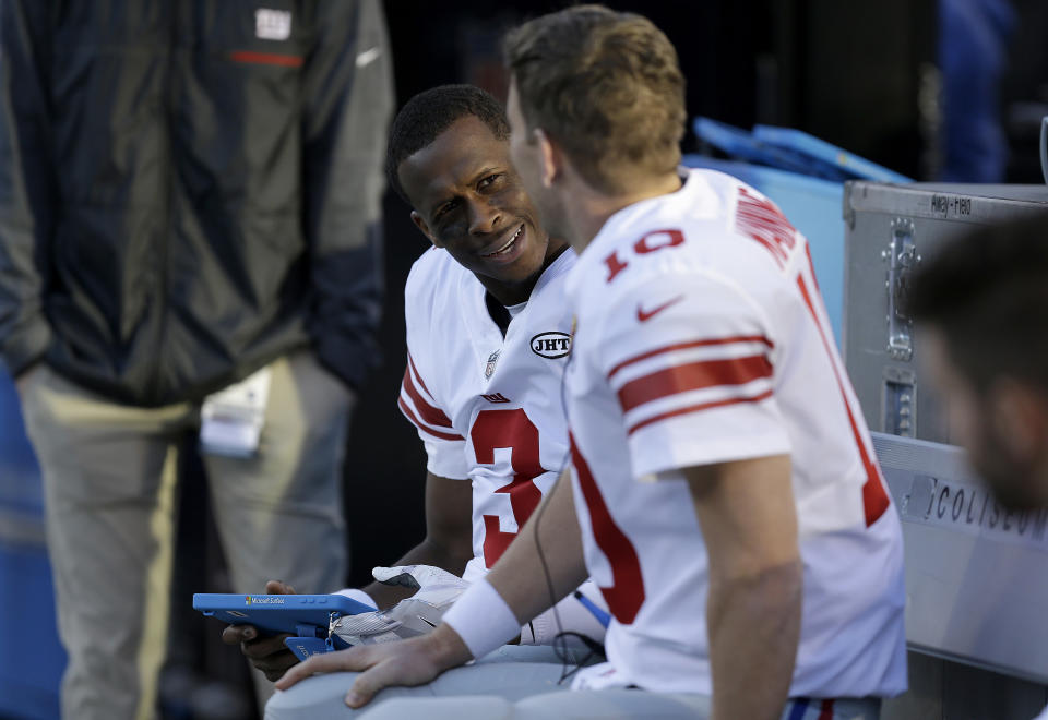 Giants quarterback Geno Smith (L) talks with quarterback Eli Manning during the second half of New York’s game against the Oakland Raiders. (AP)