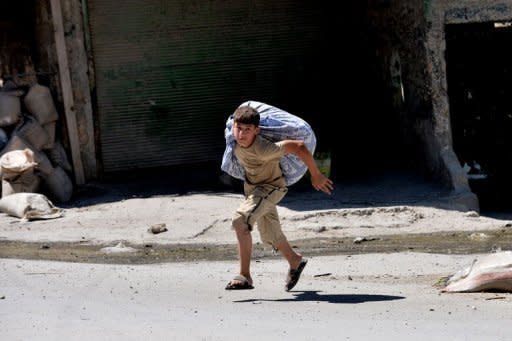 A Syrian youth runs to escape the Al Mashad neighbourhood during clashes between rebel fighters and government forces in the northern city of Aleppo on August 25. Syrian President Bashar al-Assad said on Sunday the foreign "conspiracy" against his country would be defeated, as his forces were accused of a bloody rampage