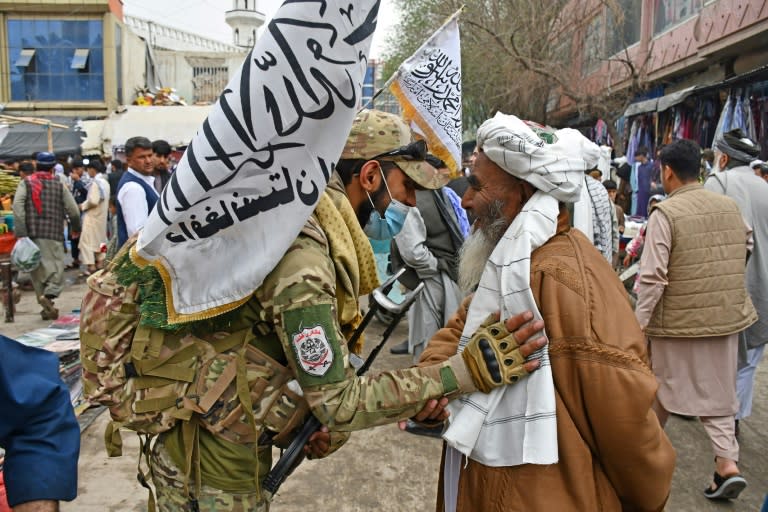 Un miembro de las fuerzas de seguridad talibanas saluda a un devoto musulmán el 10 de abril de 2024 en una mezquita en Pul-e-Khumri, Afganistán (Atif Aryan)
