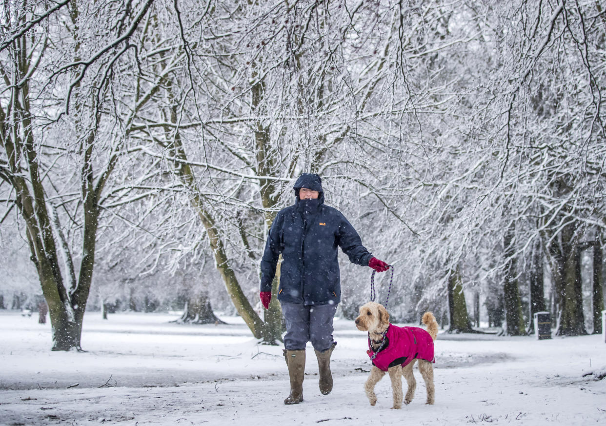 A woman walks a dog in snowy conditions in Bedale, North Yorkshire after overnight snow hit parts of the UK. (Photo by Danny Lawson/PA Images via Getty Images)