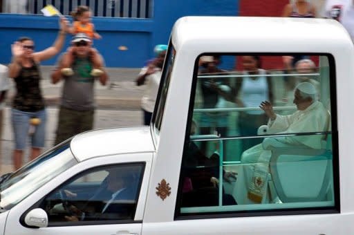 El papa Benedicto XVI se dirige en su papamóvil este 28 de marzo de 2012, hacia el aeropuerto José Martí, en La Habana, poco antes de concluir una visita de tres días a Cuba. Durante su visita, el pontífice se reunió con el presidente de Cuba, Raúl Castro, con su hermano, Fidel Castro, y encontrarse cientos de miles de cubanos. AFP Photo