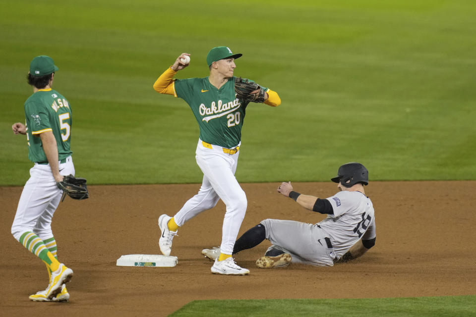 Oakland Athletics second baseman Zack Gelof (20) throws to first after forcing out New York Yankees' Jon Berti (19) at second during the seventh inning of a baseball game Saturday, Sept. 21, 2024, in Oakland, Calif. Yankees' Giancarlo Stanton scored and Anthony Volpe reached first on the play. (AP Photo/Godofredo A. Vásquez)