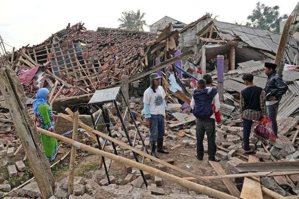 People inspect the ruins of their houses badly damaged in Monday's earthquake in Cianjur, West Java, Indonesia Tuesday, Nov. 22, 2022. The earthquake has toppled buildings on Indonesia's densely populated main island, killing a number of people and injuring hundreds. (AP Photo/Tatan Syuflana)