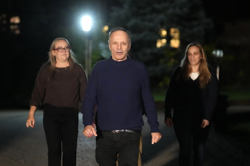 Uri Raanan walks down the driveway of his Bannockburn, Ill., home with his wife Paola Raanan, left, and his sister Sigal Zamir, to talk to reporters after his daughter Natalie and her mother Judith were released by Hamas, Friday, Oct. 20, 2023. (AP Photo/Charles Rex Arbogast)