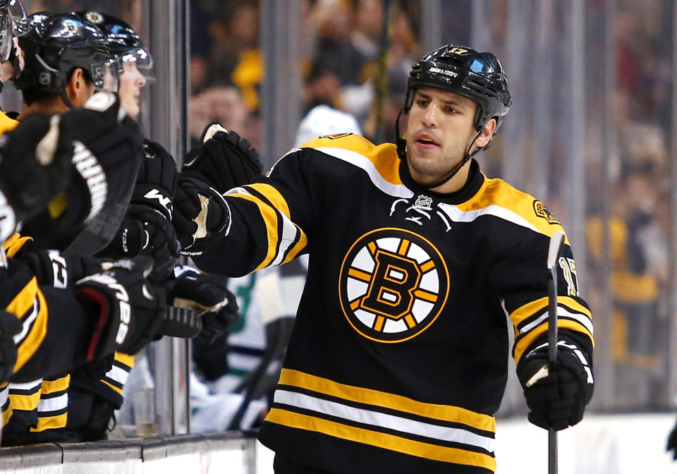 FILE - Boston Bruins' Milan Lucic is congratulated after a Boston goal against the Dallas Stars during an NHL hockey game in Boston on Feb. 10, 2015. The Bruins brought back 2011 Stanley Cup winner Lucic as part of their bargain shopping in NHL free agency. Boston signed Lucic, fellow winger James van Riemsdyk and 2020 Cup-champion defenseman Kevin Shattenkirk to contracts for next season. (AP Photo/Winslow Townson, File)