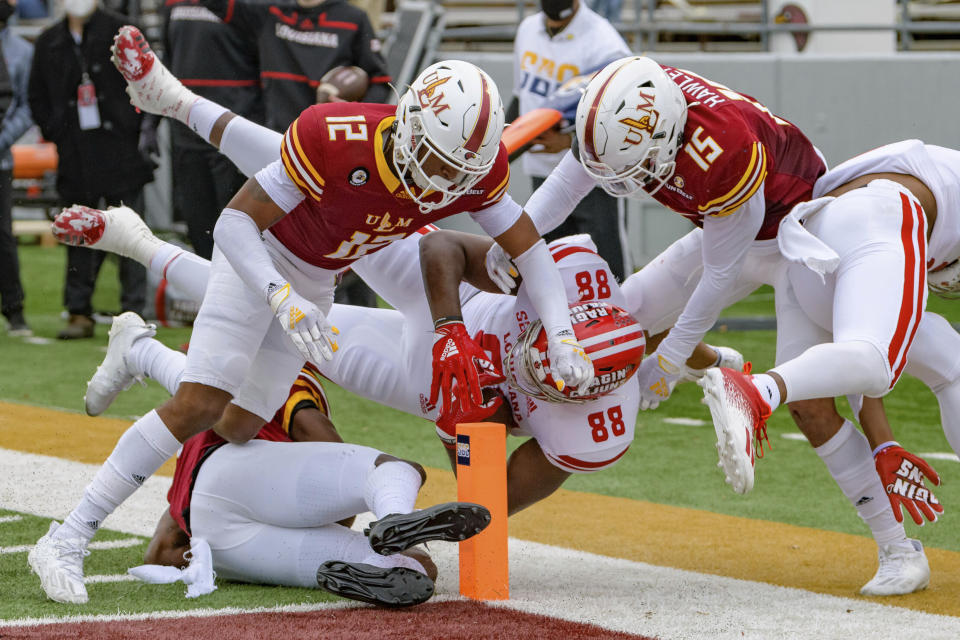 Louisiana-Lafayette tight end Johnny Lumpkin (88) is stopped short of a touchdown by Louisiana-Monroe cornerback Kenderick Marbles (12) and safety Austin Hawley (15) during the first half of an NCAA college football game in Monroe, La., Saturday, Nov. 28, 2020. (AP Photo/Matthew Hinton)