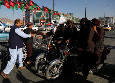 Taliban on motorbikes shake hands with people in Kabul, Afghanistan June 16, 2018.REUTERS/Mohammad Ismail