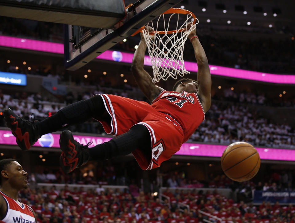 Chicago Bulls guard Jimmy Butler (21) dunks in front of Washington Wizards guard Bradley Beal in the first half of Game 3 of an opening-round NBA basketball playoff series on Friday, April 25, 2014, in Washington. (AP Photo/Alex Brandon)