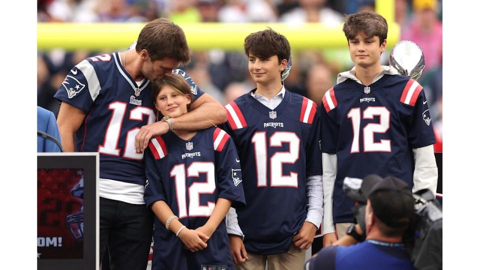 FOXBOROUGH, MASSACHUSETTS - SEPTEMBER 10: Former New England Patriots quarterback Tom Brady kisses his daughter, Vivian, while his sons, Benjamin and Jack, look on during a ceremony honoring Brady at halftime of New England's game against the Philadelphia Eagles at Gillette Stadium on September 10, 2023 in Foxborough, Massachusetts. (Photo by Maddie Meyer/Getty Images)