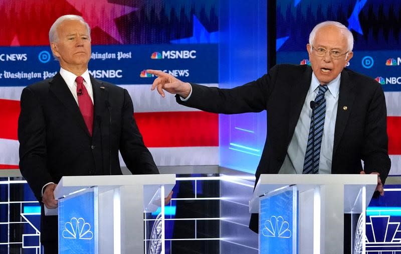 FILE PHOTO: Democratic presidential candidate former Vice President Joe Biden bends back to avoid the hand of Senator Bernie Sanders as Sanders points past Biden during the U.S. Democratic presidential candidates debate at the Tyler Perry Studios in Atlant