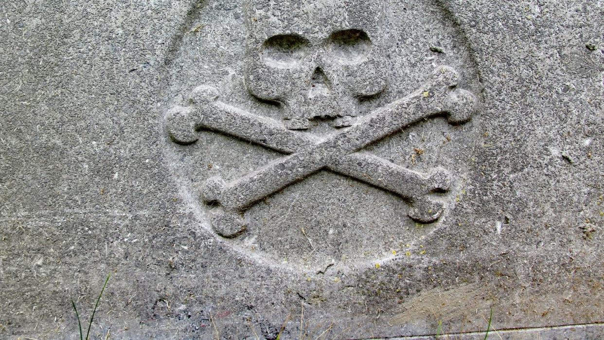 old skull and crossbones on an abandoned grave in brussels