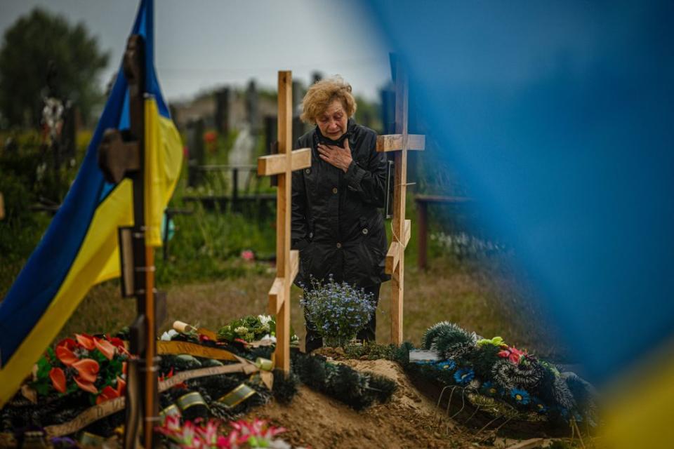 A woman mourns while visiting the grave of Stanislav Hvostov, 22, a Ukrainian serviceman killed during the Russian invasion of Ukraine, in the military section of the Kharkiv cemetery number 18 in Bezlioudivka, eastern Ukraine on May 21, 2022.<span class="copyright">Dimitar DILKOFF-AFP</span>