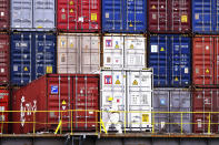 FILE - A worker in protective overall works near containers on a ship in Qingdao in east China's Shandong province on Nov. 7, 2021. China’s economy grew by 8.1% in 2021 after an abrupt slowdown in the second half that is prompting suggestions Beijing needs to shore up slumping growth, government data showed Monday, Jan. 17, 2022. (Chinatopix via AP, File)