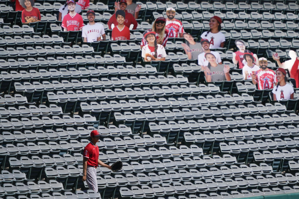 Los Angeles Angels designated hitter Shohei Ohtani (17) looks for stray baseballs in the stands near cutouts of fans during practice at Angels Stadium on Friday, July 3, 2020, in Anaheim, Calif. (AP Photo/Ashley Landis)