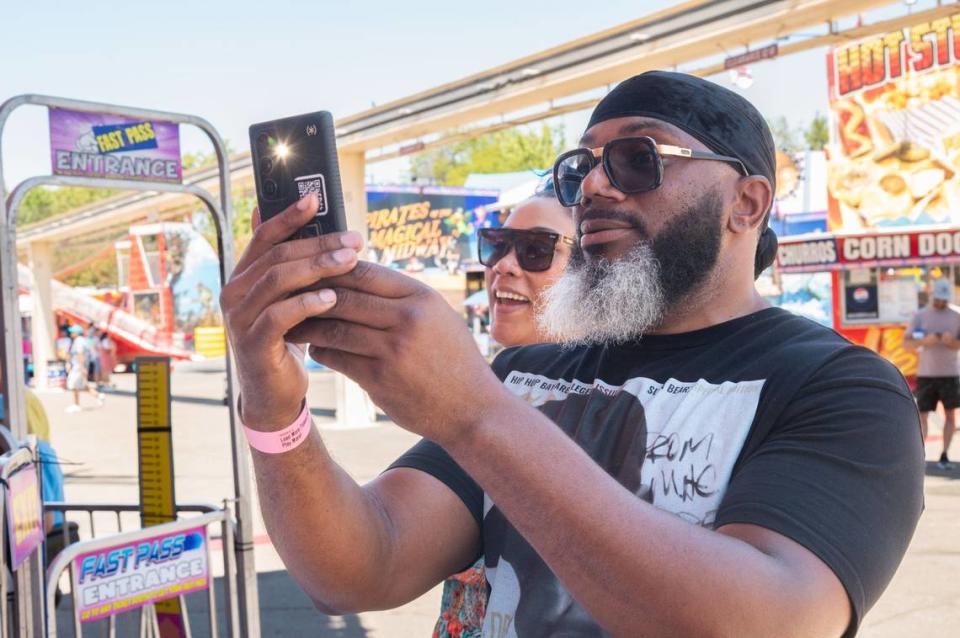 Queonte Auque takes a photo of his 11-year-old daughters on the Hawaiian Express at the California State Fair on Tuesday. “I won a huge blue Cookie Monster for my lady,” Auque said, “but spending time with my girls was the best part.”