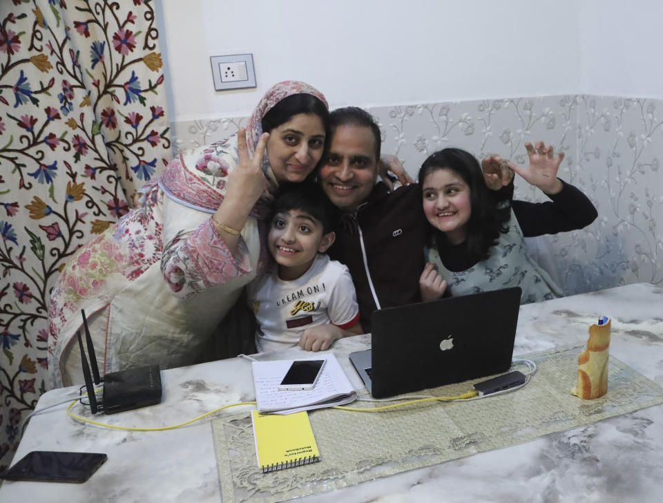 Associated Press photographer Mukhtar Khan celebrates with his family at his home in Srinagar, Indian controlled Kashmir, Tuesday, April 5, 2020, following the announcement that he was one of three AP photographers who won the Pulitzer Prize in Feature Photography for their coverage of the conflict in Kashmir and in Jammu, India. (AP Photo/Afnan Arif)