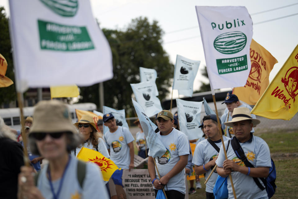 Farmworkers and allies listen to speakers before embarking on a five-day trek aimed at highlighting the Fair Food Program, which has enlisted food retailers to use their clout with growers to ensure better working conditions and wages for farmworkers, Tuesday, March 14, 2023, in Pahokee, Fla. (AP Photo/Rebecca Blackwell)